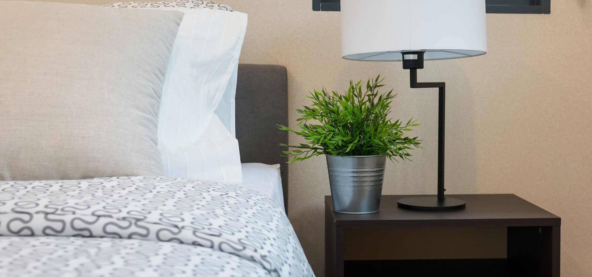 modern-bedroom-with-white-lamp-and-plants-on-table